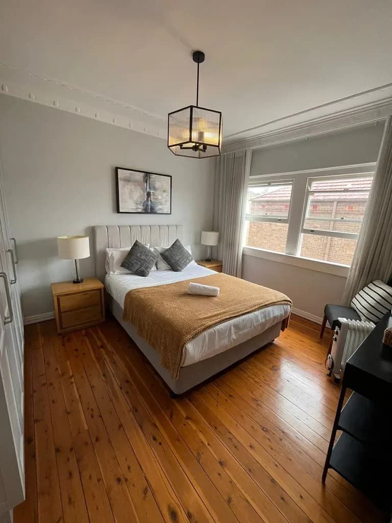 A bedroom staged after an Orison changeover: bed made with a folded throw and towels