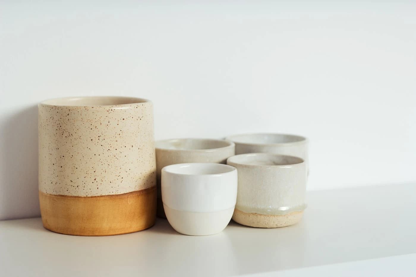 Handmade ceramic cups arranged on a clean benchtop
